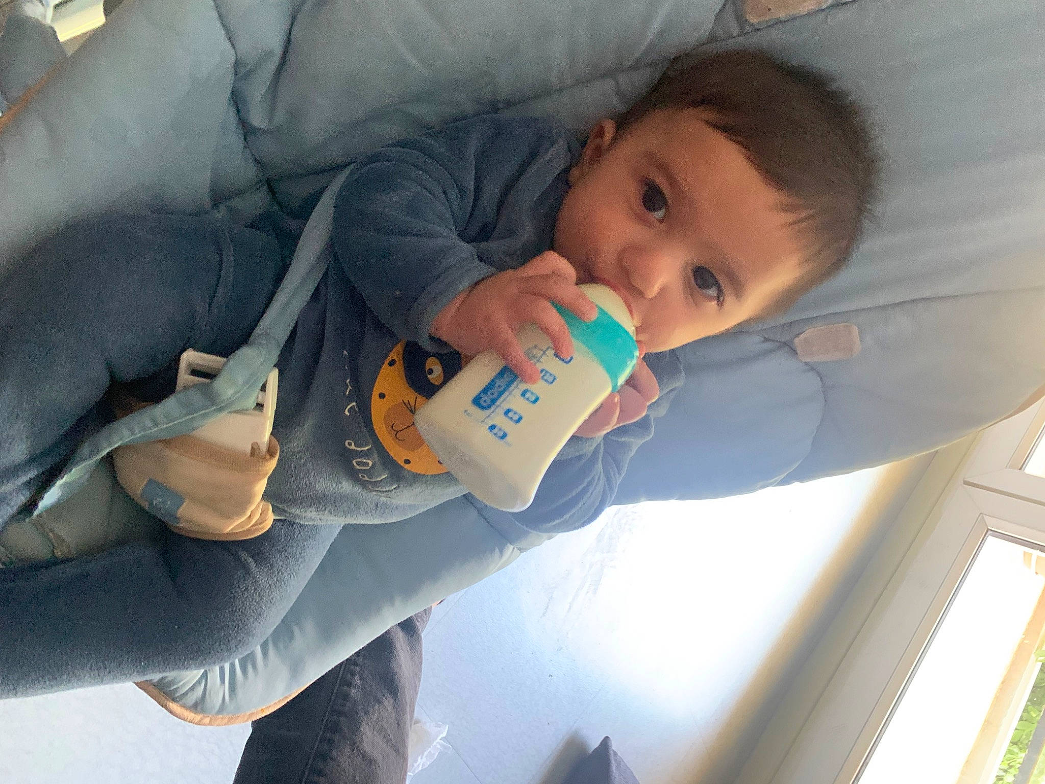 Kassim participe au concours pour gagner de l'argent avec cette photo : baby, baby_products, baby_toddler_clothing, child, comfort, denim, drinkware, elbow, electric_blue, finger, head, human_leg, knee, person, sitting, skin, thigh, toddler, winter