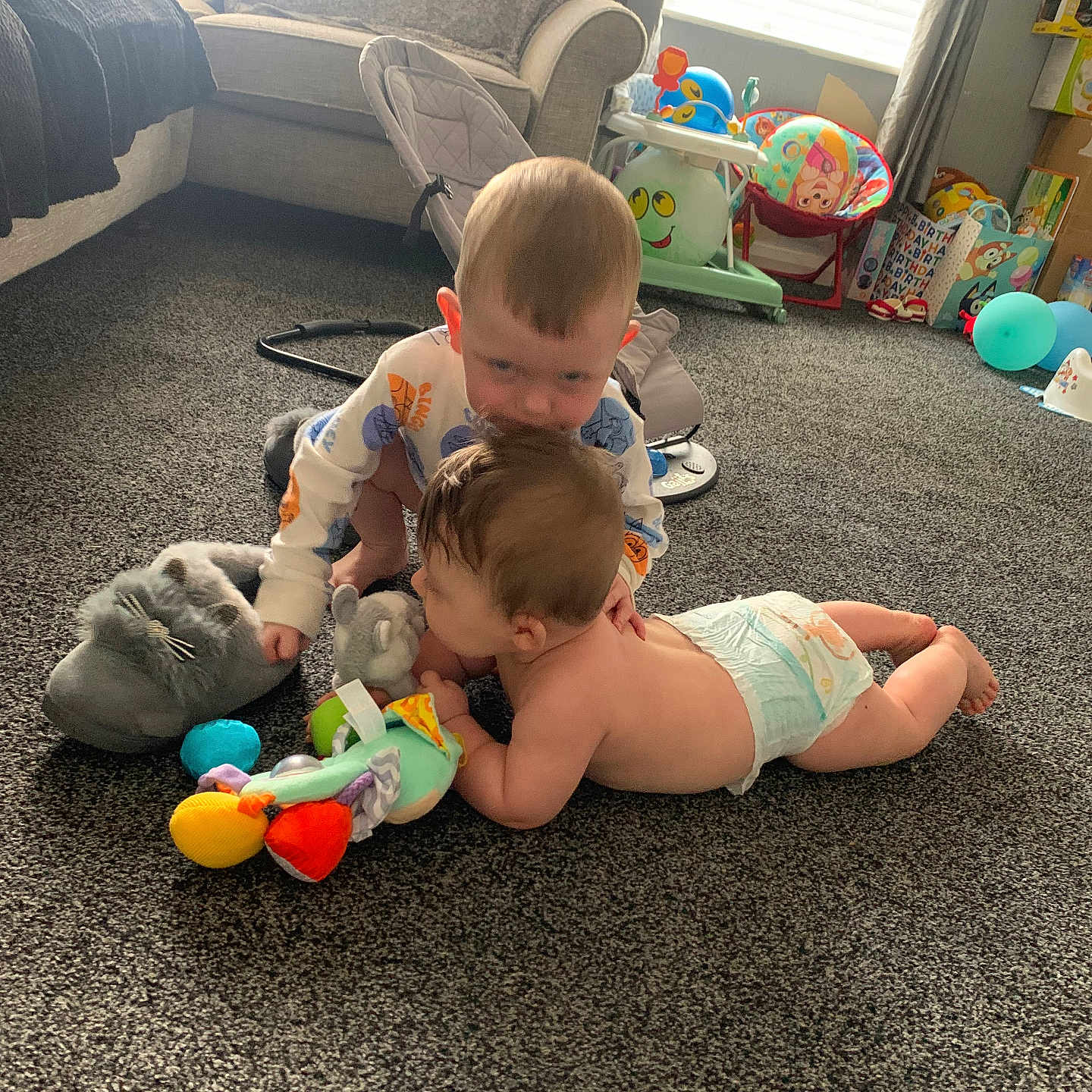 Kyle And Noah is registered to the contest to win money with this photo: baby, balloon, birthday, carpet, carpeted_floor, child, childcare, curtain, cute, diaper, floor, furniture, home, living_room, play, sofa, stuffed_toy, toddler, toy, window