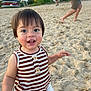 beach, child, daytime, happy, kayaks, nature, outdoor, people, playful, portrait, sand, striped_clothing, summer, sunlight, tank_top, toddler, trees, walking, water_sports_equipment, white_shorts