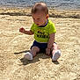 Hunner joined the competition — help win amazing prizes! baby, child, sand, water, beach, sitting, outdoor, sunlight, casual_clothing, sock, shorts, green_shirt, nature, shallow_water, daytime, curious, young_child, barefoot, playful, summer