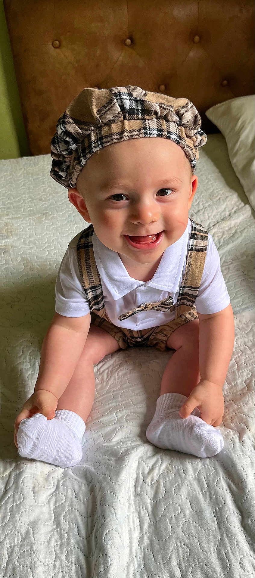 Hunner joined the competition — help win amazing prizes! baby, child, smiling, plaid, hat, suspenders, white_shirt, socks, bed, quilt, indoor, cute, happy, infant, person, portrait, skin, face, hands, legs