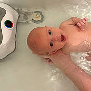 Kashton is registered to the contest to win money with this photo: baby, bath, bathroom, care, child, clean, expression, face, floating, hand, head, infant, milky_water, naked, person, skin, support, tub, water, young