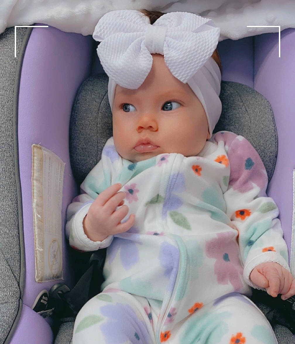 Elaina joined the competition — help win amazing prizes! baby, baby_products, baby_safety, baby_sleeping, baby_toddler_clothing, cap, cheek, child, comfort, costume_hat, fashion_accessory, headwear, linens, pattern, person, pink, product, sitting, sleeve, textile