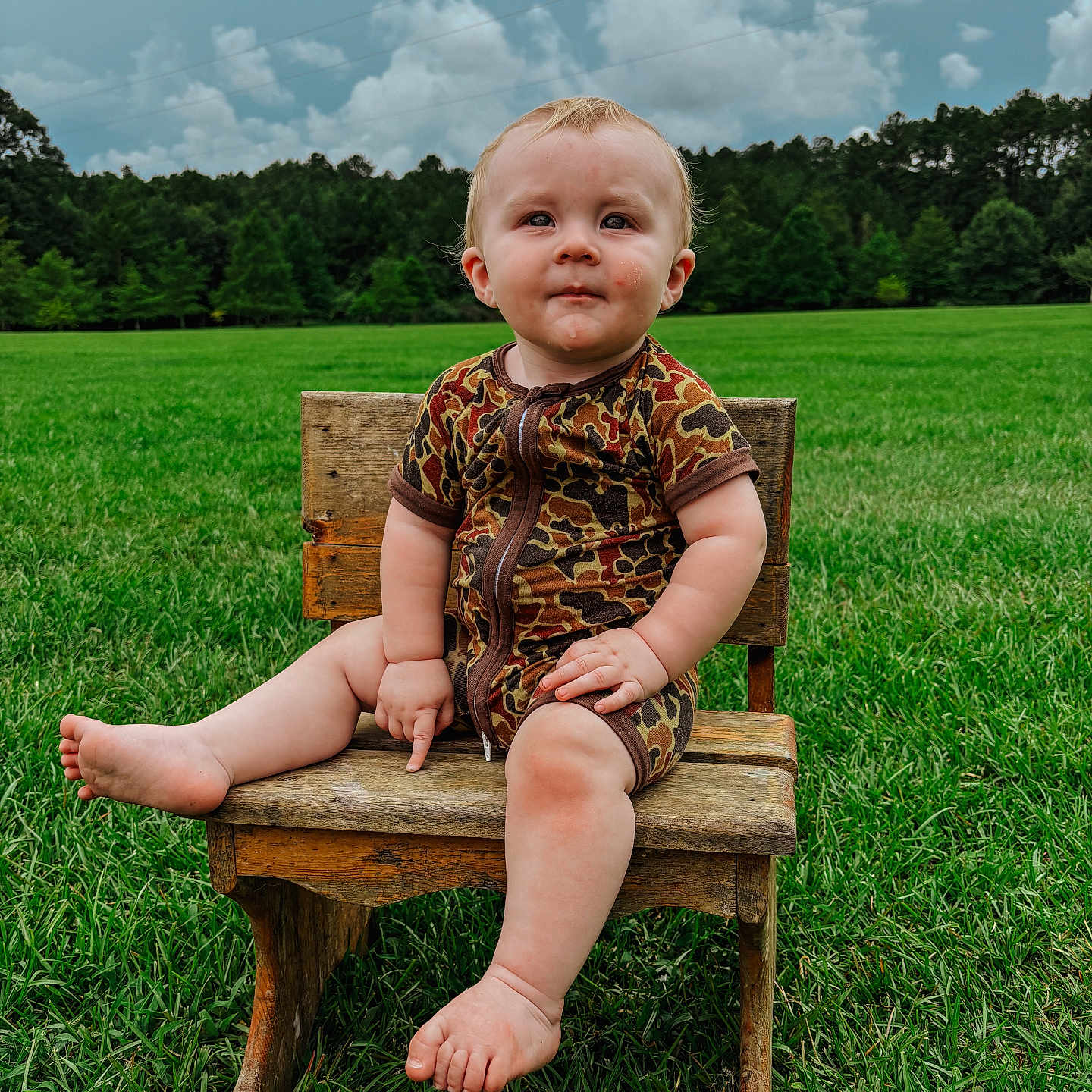 Bowen is registered to the contest to win money with this photo: baby, bodypart, chair, clothing, dress, face, finger, furniture, grass, hand, hardwood, head, lawn, outdoors, person, photography, plant, portrait, sitting, wood