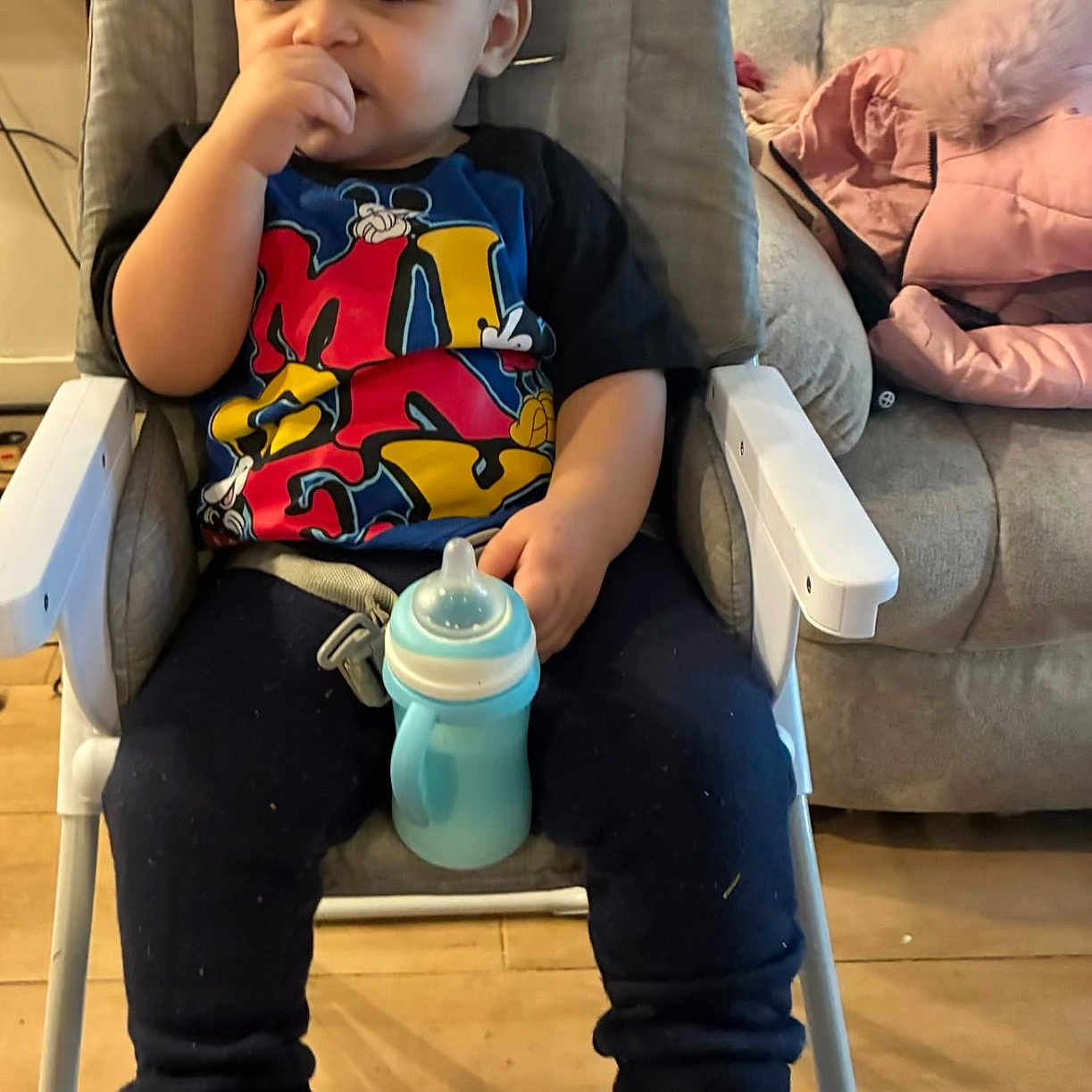 Zayne joined the competition — help win amazing prizes! child, toddler, high_chair, sippy_cup, boots, clothing, indoors, floor, couch, furniture, person, face, hand, sitting, wooden_floor, casual, home, young_child, cute, thinking