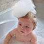 baby, bubble_bath, foam, bathtub, child, cute, water, skin, wet_hair, blue_eyes, bathroom, tiled_wall, playful, foam_hat, infant, chubby_arms, curious, sitting, cleaning, childhood