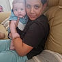 affection, baby, beige, candid, casual_clothing, child, comfort, couch, family, holding, home, indoor, living_room, person, pillow, portrait, sitting, toddler, together, wide_eyes
