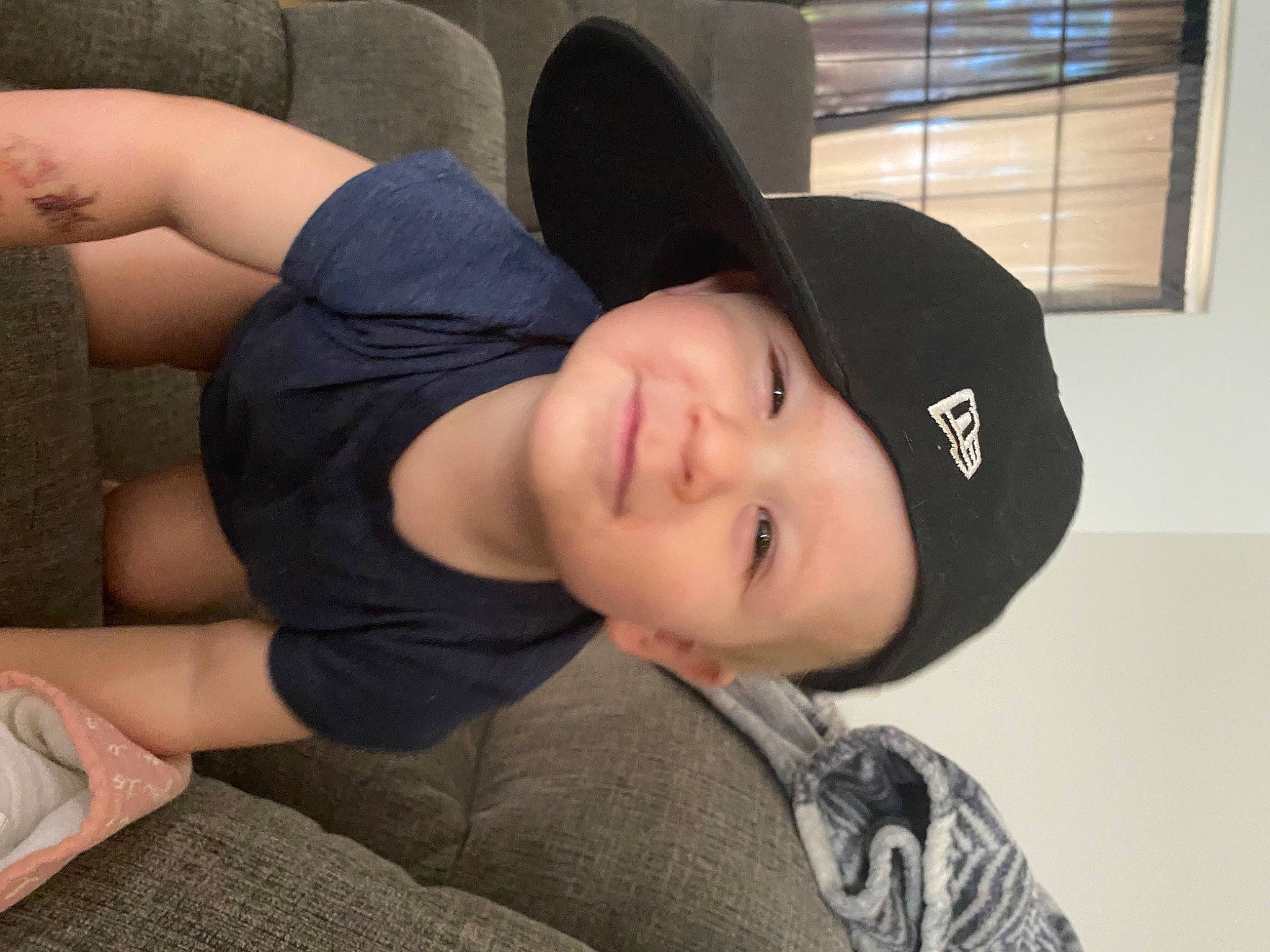 Jaxton is registered to the contest to win money with this photo: black_hair, comfort, elbow, fashion_accessory, fun, fur, hat, headwear, human_leg, joy, knee, person, shoulder, sitting, sleeve, smile, sun_hat, thigh, window