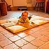 Isaac participe au concours pour gagner de l'argent avec cette photo : baby, child, floor, quilt, tile_floor, smiling, indoor, radiator, chair, blanket, cushion, person, home, cozy, wooden_leg, curtain, toy, happy, infant, casual