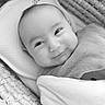baby, infant, smile, blanket, basket, woven_basket, face, portrait, newborn, cute, wrapped, cozy, child, black_and_white, soft_texture, lying_down, happy, head, closeup, peaceful