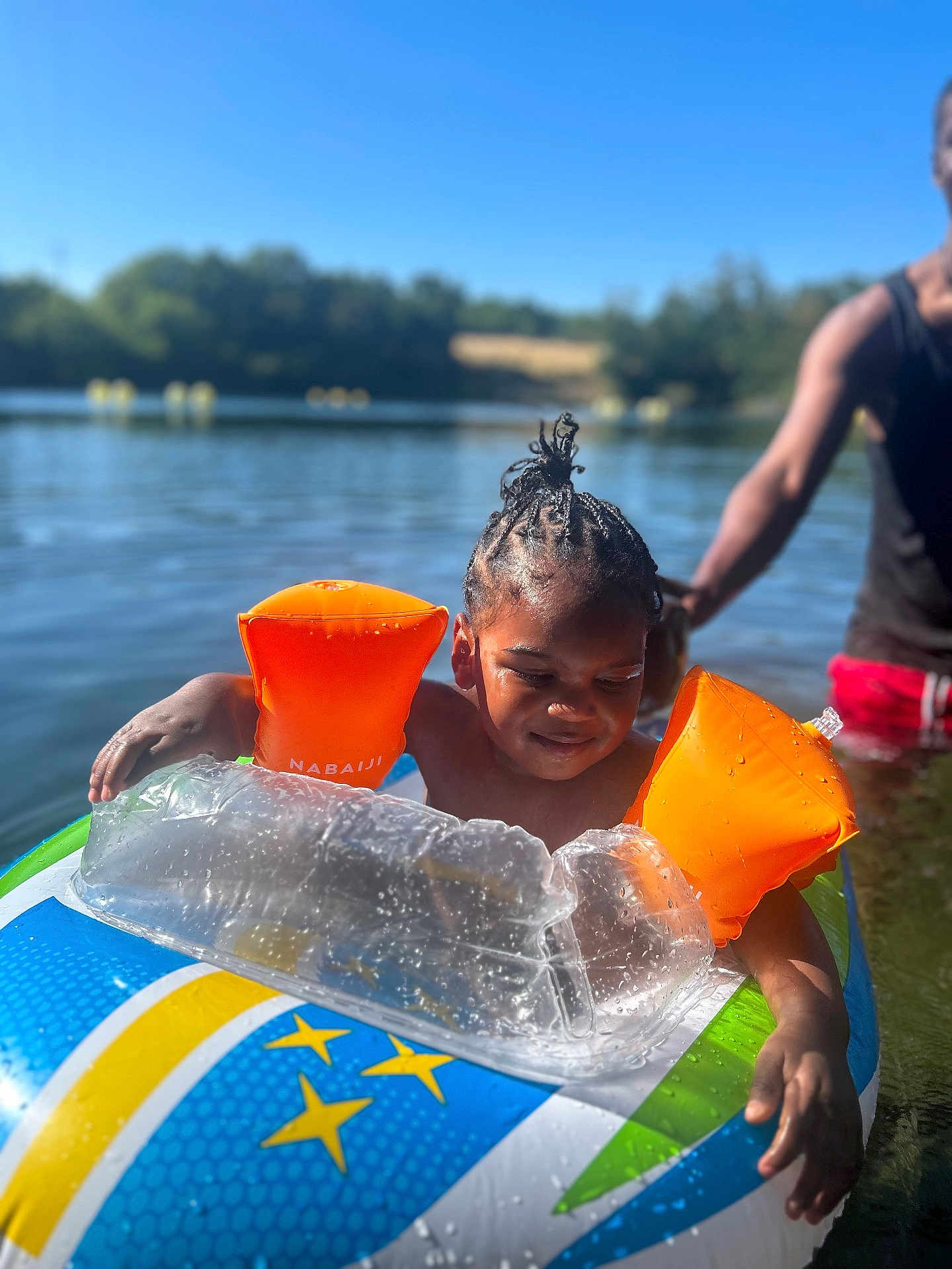 Keylane participe au concours pour gagner de l'argent avec cette photo : child, lake, water, inflatable, float, arm_floaties, summer, sunny, outdoor, person, braids, swimming, recreation, nature, adult, playful, water_safety, blue_sky, greenery, fun