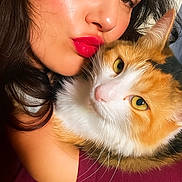 Saturne participe au concours pour gagner de l'argent avec cette photo : affection, cat, closeup, cuddle, dark_hair, expression, eyebrows, face, feline, fur, indoor, nose, pet, portrait, red_lipstick, skin, warm_light, whiskers, woman, yellow_eyes