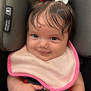 Alaya is registered to the contest to win money with this photo: baby, child, smiling, car_seat, bib, hair_bow, red_bow, white_bow, infant, cute, face, hand, seatbelt, closeup, adorable, portrait, skin, clothing, happy, indoor