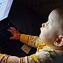Lainey is registered to the contest to win money with this photo: baby, child, laptop, keyboard, screen, technology, curious, hands, face, side_view, indoors, dim_light, pajamas, person, young_child, exploration, close_up, night, technology_use, infant
