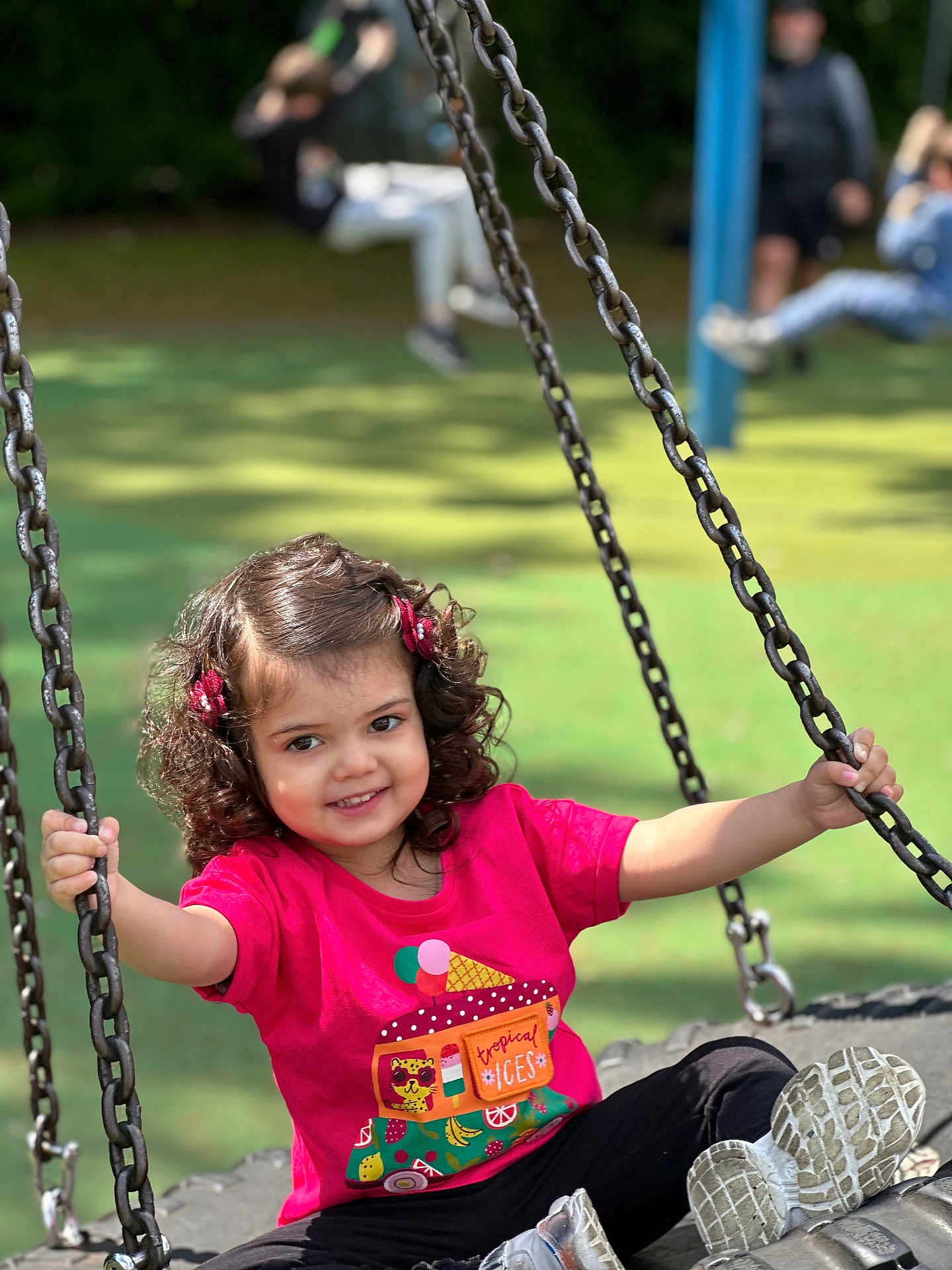 Ayzel joined the competition — help win amazing prizes! child, girl, swing, playground, outdoor, smile, curly_hair, pink_hair_clips, red_shirt, black_pants, sneakers, chains, daylight, green_background, fun, recreation, happy, park, activity, cute