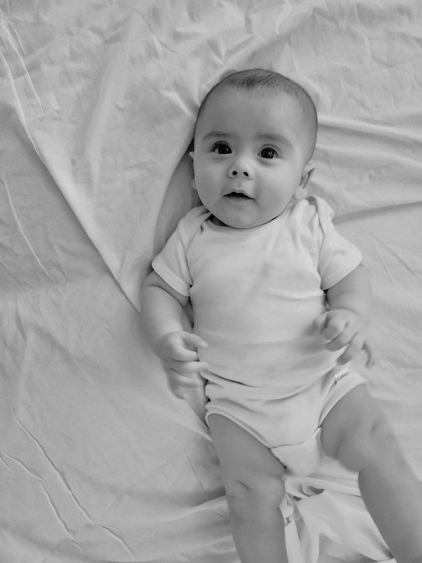Reign joined the competition — help win amazing prizes! baby, bed, black_and_white, child, cute, face, hands, indoors, infant, legs, looking_up, lying_down, monochrome, onesie, person, portrait, sheet, soft_light, wrinkles, young