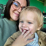 Tiago participe au concours pour gagner de l'argent avec cette photo : blue_eyes, casual, child, closeup, face, family, fun, glasses, hand, happy, indoor, jacket, people, portrait, seats, smile, stadium, sweater, toddler, woman