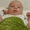 William is registered to the contest to win money with this photo: baby, baby_face, baby_hand, blanket, child, curious_expression, cute, dinosaur_print, face, green_blanket, head, indoor, infant, infant_clothing, lying_down, portrait, skin_condition, soft_texture, white_clothing, young_child