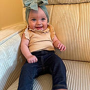 Georgia joined the competition — help win amazing prizes! baby, child, smiling, headband, bow, jeans, top, sitting, couch, furniture, indoors, happy, cute, portrait, person, infant, clothing, comfort, relaxed, bright