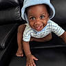 toddler, child, baby, hat, blue, striped_shirt, crawling, smiling, happy, black_leather_couch, furniture, indoor, person, cute, playful, motion_blur, young_child, skin, hand, foot