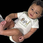 Silas joined the competition — help win amazing prizes! baby, child, onesie, smile, face, foot, hand, animal_print, text_on_clothing, cute, infant, skin, black_background, happy, portrait, sitting, young_child, diaper, playful, casual_clothing