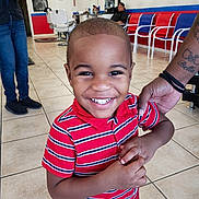 King joined the competition — help win amazing prizes! child, boy, smile, barbershop, striped_shirt, tattoo, hand, chair, floor_tiles, interior, person, waiting, mirror, door, poster, casual_clothing, happy, indoor, portrait, haircut