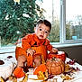 baby, pumpkin, orange_clothing, ceramic_pumpkin, autumn_leaves, indoors, window, fall, child, seasonal, cute, portrait, sitting, decor, holiday, table, leaf_litter, footwear, expression, natural_light