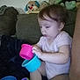 toddler, child, plastic_cups, stacking, couch, plush_toys, indoor, curious, baby, playing, seat, furniture, person, young_child, casual_clothing, soft_toys, home, exploration, sitting, colorful