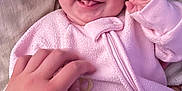 Valerie joined the competition — help win amazing prizes! baby, infant, smiling, tongue_out, pink_onesie, hand, tickling, blanket, cozy, cute, happy, sleepwear, child, face, portrait, indoor, soft_texture, warm, playful, human