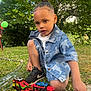 Jayden participe au concours pour gagner de l'argent avec cette photo : child, toddler, toy_car, car_toy_trailer, denim_jacket, grass, outdoor, balloon, sneakers, play, greenery, garden, summer, casual_clothing, boy, kneeling, curious, daylight, nature, fun