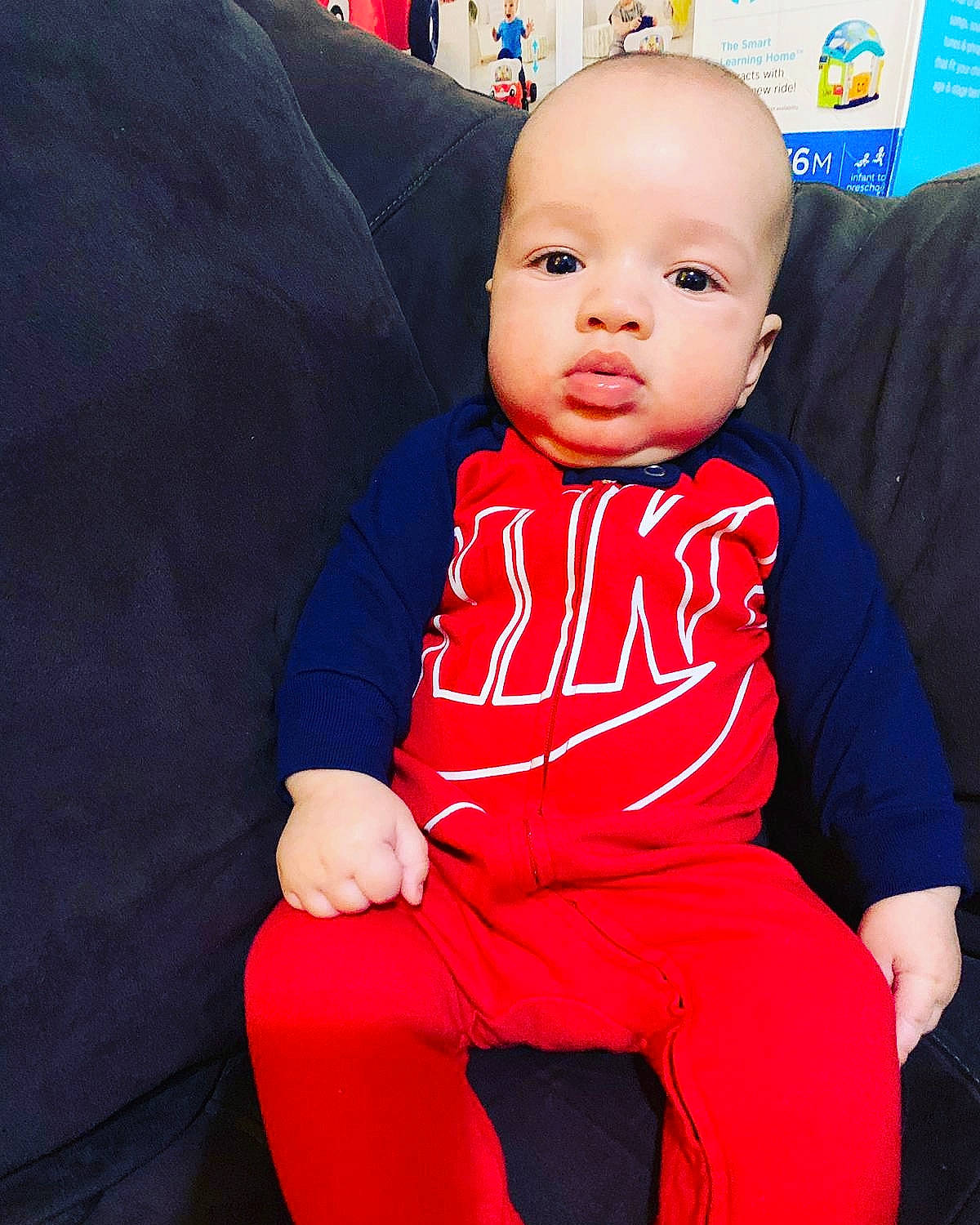 Raul is registered to the contest to win money with this photo: baby, blue, child, outerwear, person, red, sitting, skin, toddler