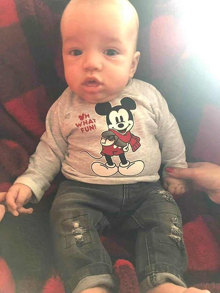 Raul is registered to the contest to win money with this photo: arm, boy, cheek, child, cool, facial_expression, head, human, infant, mouth, nose, person, pink, product, sitting, skin, smile, standing, t_shirt, textile