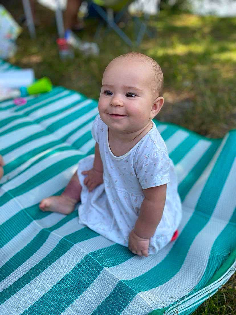 Maëlle participe au concours pour gagner de l'argent avec cette photo : aqua, azure, baby, baby_toddler_clothing, child, electric_blue, flooring, fun, grass, happy, joy, leaf, leisure, pattern, people_in_nature, person, play, recreation, sitting, smile