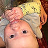 Westin is registered to the contest to win money with this photo: baby, infant, hand, face, eyes, yellow_clothing, cartoon_print, sucking_thumb, upside_down, person, child, cute, skin, head, hair, human, indoor, supporting_hand, blanket, warm_lighting