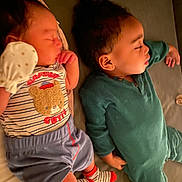 Iverson is registered to the contest to win money with this photo: baby, bed, child, clothing, cute, cute_outfit, face, family, indoor, infant, lying_down, nap, onesie, peaceful, person, rest, sleeping, socks, soft_surface, toddler
