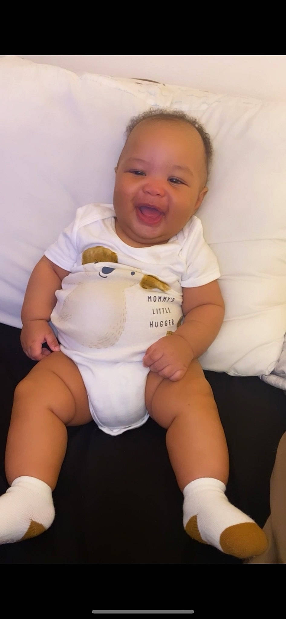 Carmelo is registered to the contest to win money with this photo: arm, baby_toddler_clothing, cheek, comfort, eye, finger, head, joint, knee, leg, neck, person, pink, shoulder, skin, sleeve, smile, stomach, textile, thigh