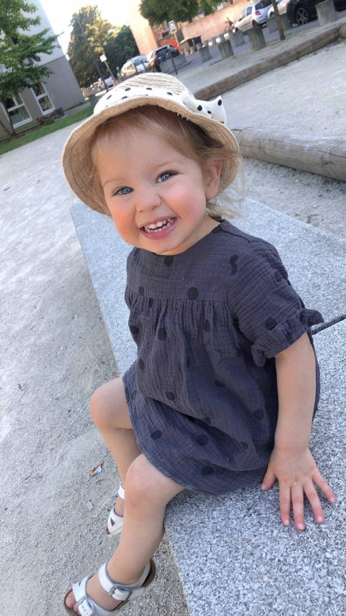 Feryah a rejoint le concours — aidez-le/la à gagner de superbes lots ! baby_toddler_clothing, cap, child, dress, electric_blue, fashion_accessory, fun, grass, hairstyle, happy, hat, headgear, human_leg, joy, pattern, person, sitting, sleeve, smile, standing