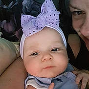 Reign is registered to the contest to win money with this photo: baby, infant, adult_face, headband, bow, closeup, portrait, chubby_cheeks, eyes, hand, skin, pillow, blanket, indoor, fashion_accessory, smile, person, cute, parenting, cozy