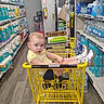 Rhiannon joined the competition — help win amazing prizes! baby, blonde_hair, blue_eyes, bottled_water, cart, child, grocery_store, indoor, looking_at_camera, portrait, retail, seated, shelves, shopping, shopping_cart, silver_shoes, store_aisle, toddler, toilet_paper, yellow_shirt