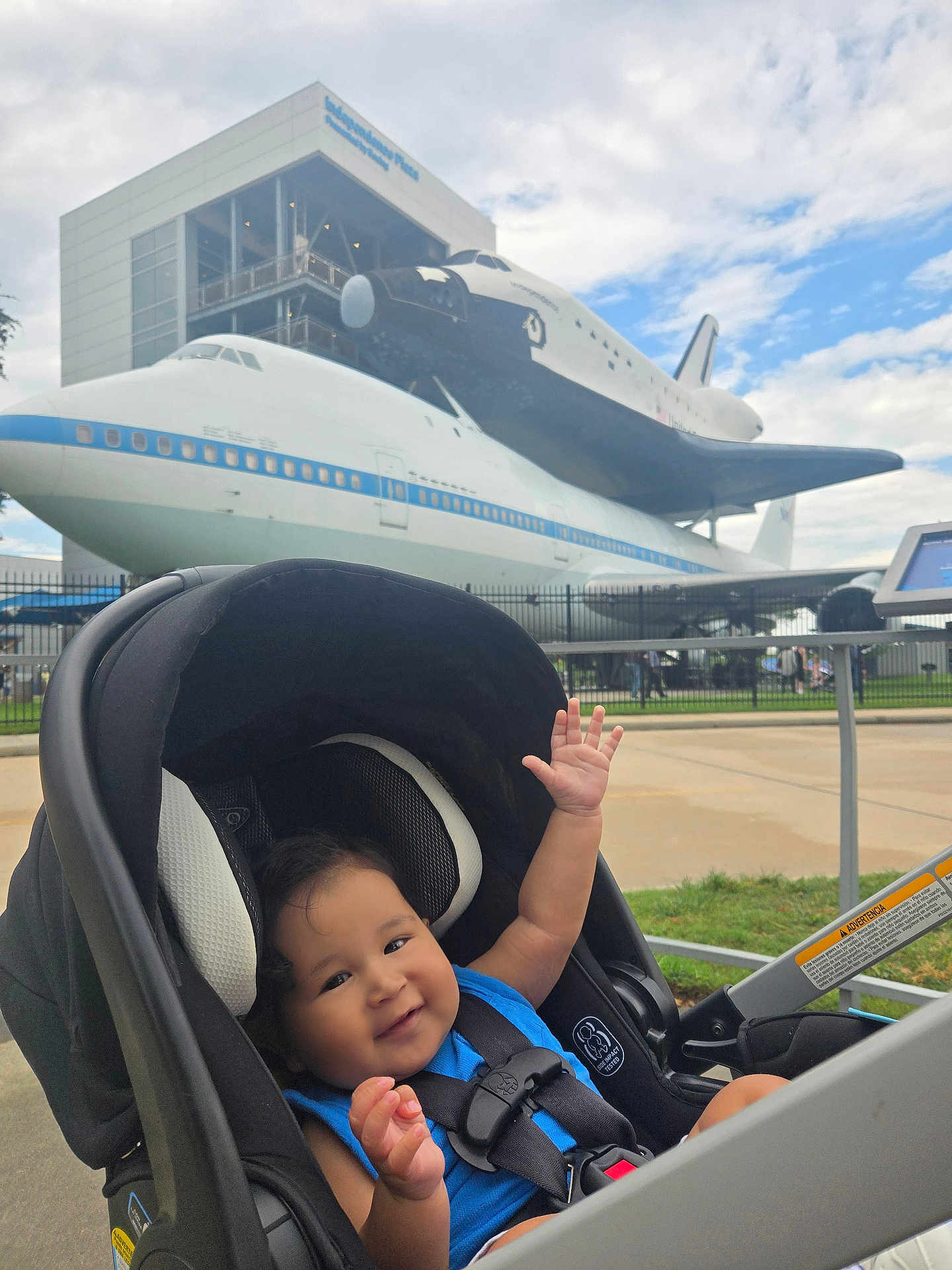 Andrew joined the competition — help win amazing prizes! airplane, baby, blue_shirt, child, clouds, daytime, fence, happy, infant, outdoor, park, pavement, seatbelt, sky, smiling, space_shuttle, stroller, technology, tourist_attraction, transportation