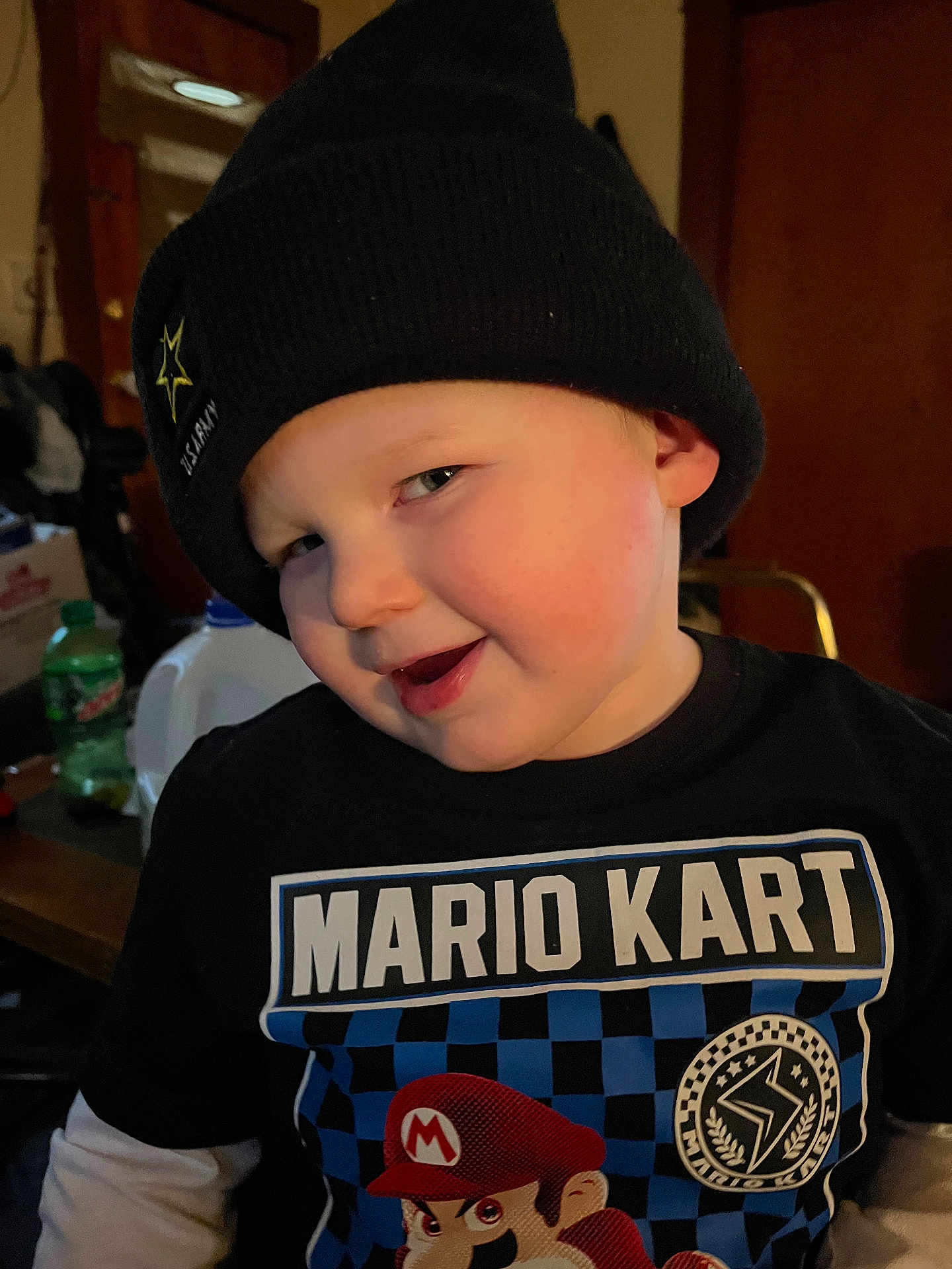 Joshua joined the competition — help win amazing prizes! child, toddler, boy, hat, beanie, black_hat, smile, indoor, shirt, mario_kart, graphic_tshirt, face, person, casual, cute, young_child, portrait, headwear, clothing, expression
