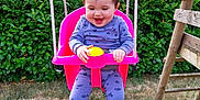 Inaya a rejoint le concours — aidez-le/la à gagner de superbes lots ! baby, barefoot, child, daylight, fun, grass, greenery, happy, hedge, nature, outdoor, person, playground, purple_clothing, seat, smiling, swing, toy, wooden_ladder, young