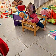 Inaya participe au concours pour gagner de l'argent avec cette photo : activity_center, cheerful, child, colorful, curtain, cushions, doll, floor, indoor, messy_room, pink_shirt, play_tent, playroom, radiator, tiles, toddler, tongue_out, toy_table, toys, wooden_bed