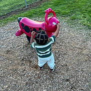 Jabrayden joined the competition — help win amazing prizes! toddler, child, playground, toy, red, outdoor, grass, woodchips, fence, green, person, back_view, clothing, sneakers, hairstyle, play, reaching, daylight, park, fun