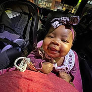 Harlow joined the competition — help win amazing prizes! baby, smiling, headband, car_interior, car_seat, night, child, clothing, seatbelt, storefront, window, face, person, cute, happy, indoors, infant, portrait, seat, toy