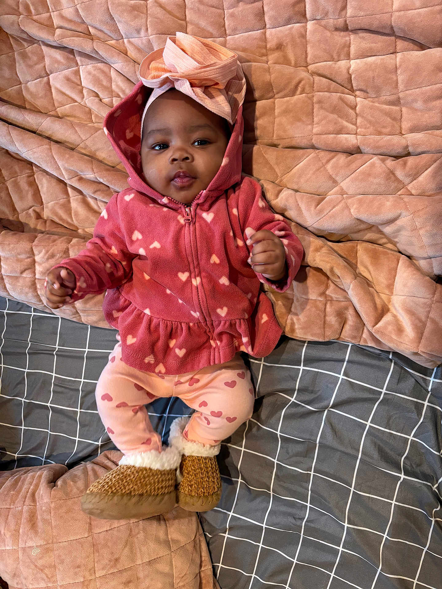 Harlow joined the competition — help win amazing prizes! baby, infant, child, pink_clothing, hoodie, leggings, slippers, headband, bow, blanket, quilt, bedspread, plaid_pattern, heart_pattern, soft_texture, indoors, cute, portrait, smiling, relaxed