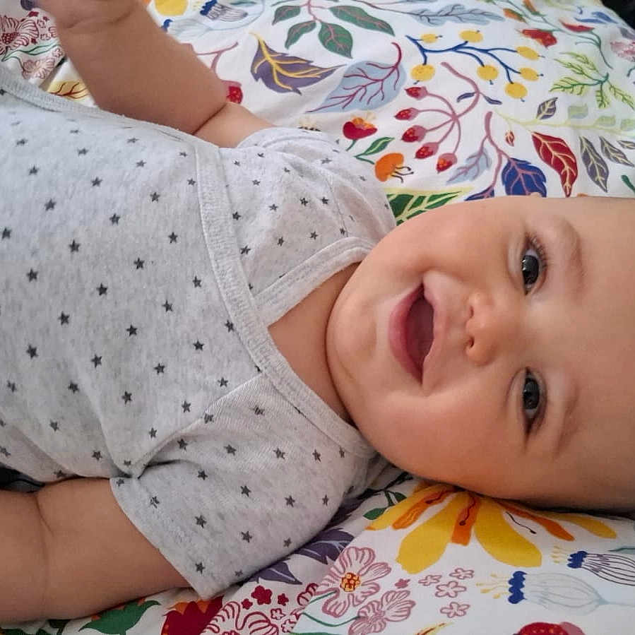 Aylan a rejoint le concours — aidez-le/la à gagner de superbes lots ! baby, baby_boy, baby_girl, blanket, cheerful, child, closeup, clothing, cute, face, floral_pattern, happy, indoor, infant, lying_down, onesie, person, portrait, skin, smiling