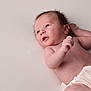 baby, newborn, infant, diaper, face, head, eyes, hair, arm, hand, skin, lying_down, studio_background, portrait, cute, curious, sleepy, soft_texture, newborn_photography, minimalist