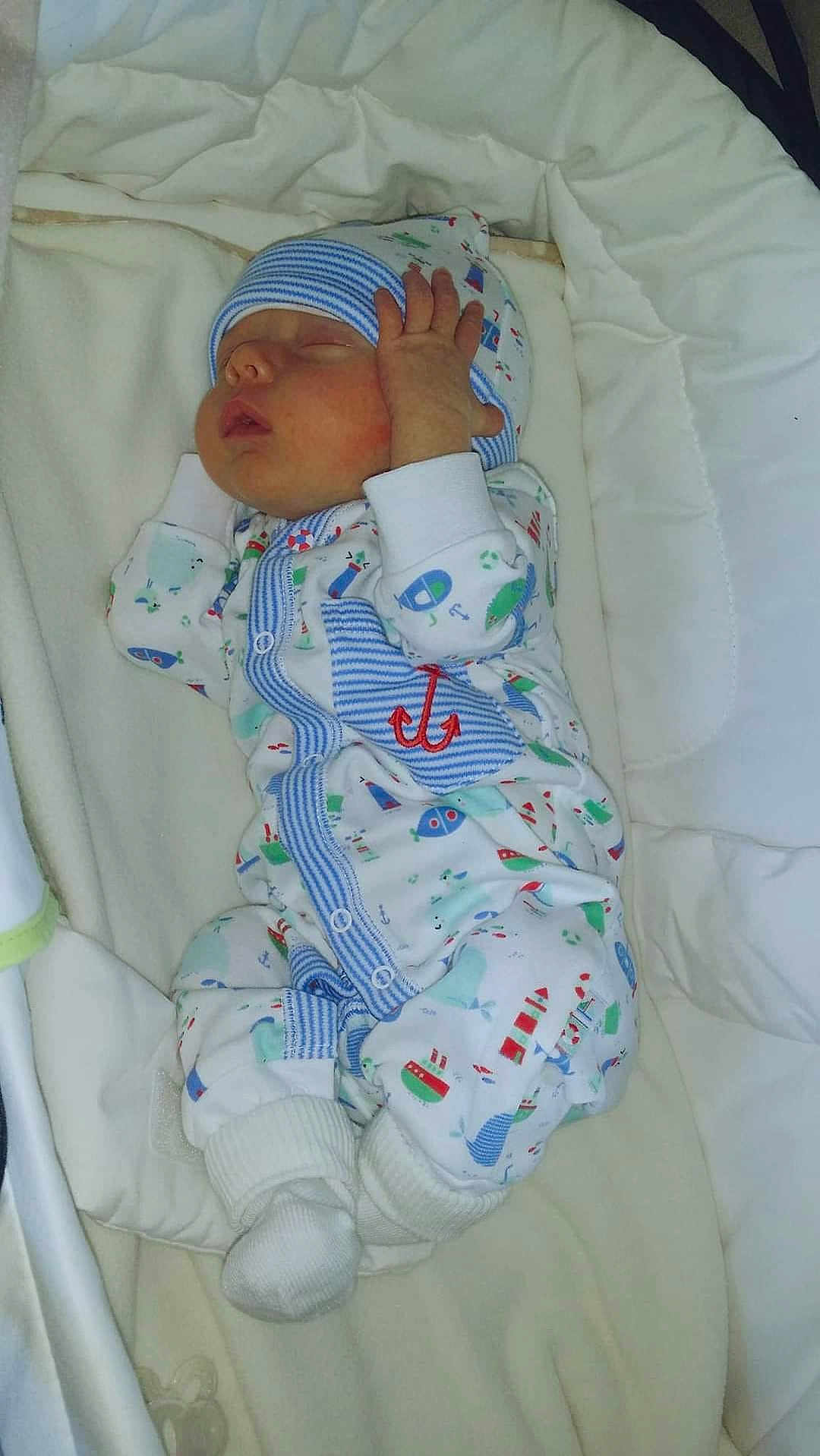 Kaiden is registered to the contest to win money with this photo: baby, newborn, sleeping, onesie, hat, hand, face, cushion, blanket, soft, comfort, infant, clothing, cute, indoor, resting, peaceful, small, child, wearing