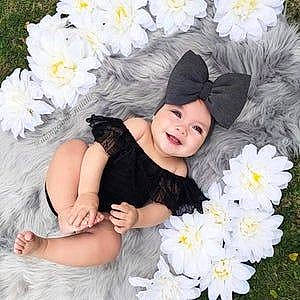 Laura joined the competition — help win amazing prizes! baby_toddler_clothing, dress, eye, face, facial_expression, flower, grass, happy, head, headgear, headwear, joy, people_in_nature, person, petal, pink, plant, skin, smile, textile